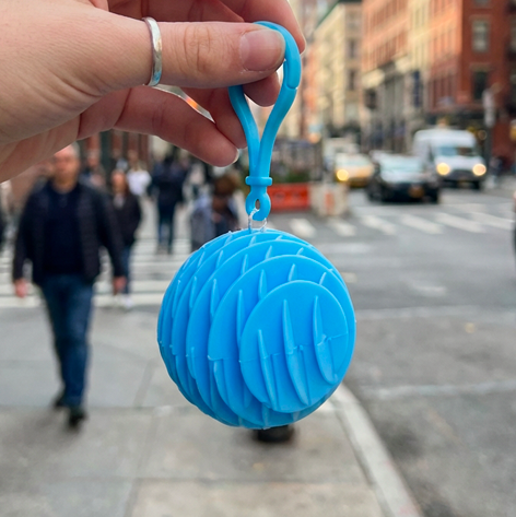 Blue Chroma Coil being carried in a city street setting - Stylish and functional EDC fidget accessory