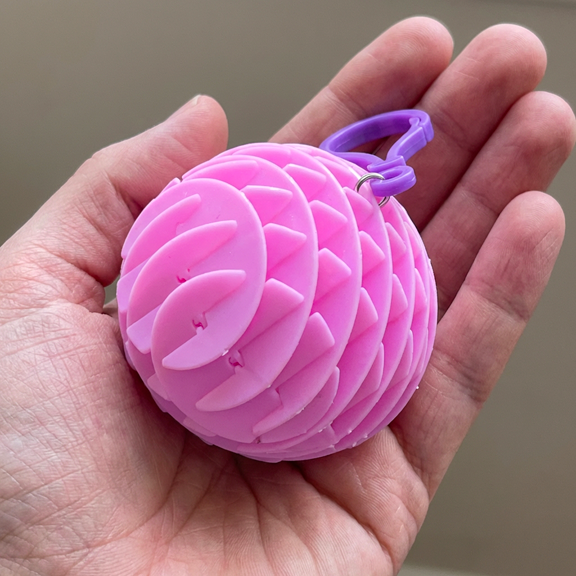 Pink Chroma Coil held in palm to show the flexible helical structure and lightweight portable design