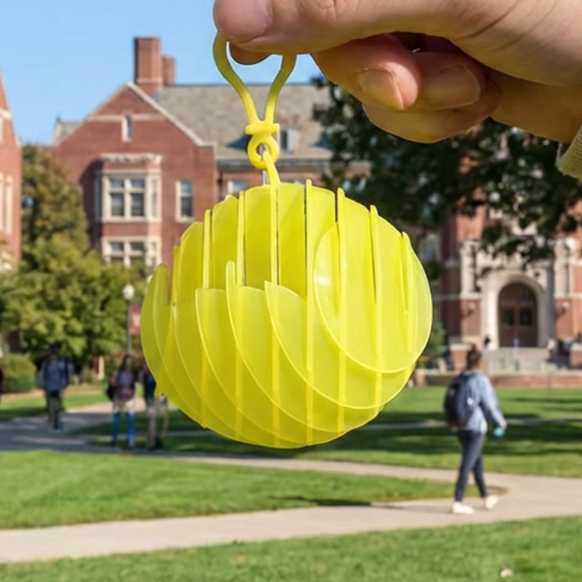 Yellow Chroma Coil sensory ball with integrated keychain clip for easy attachment to bags or gear